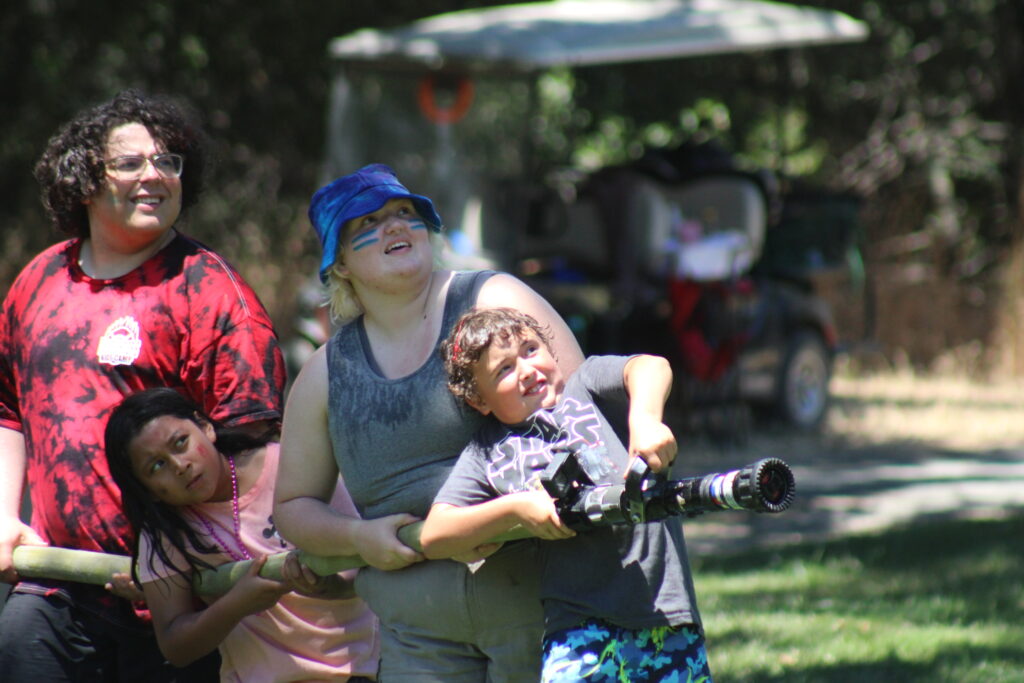 Group of kids holding fire hose