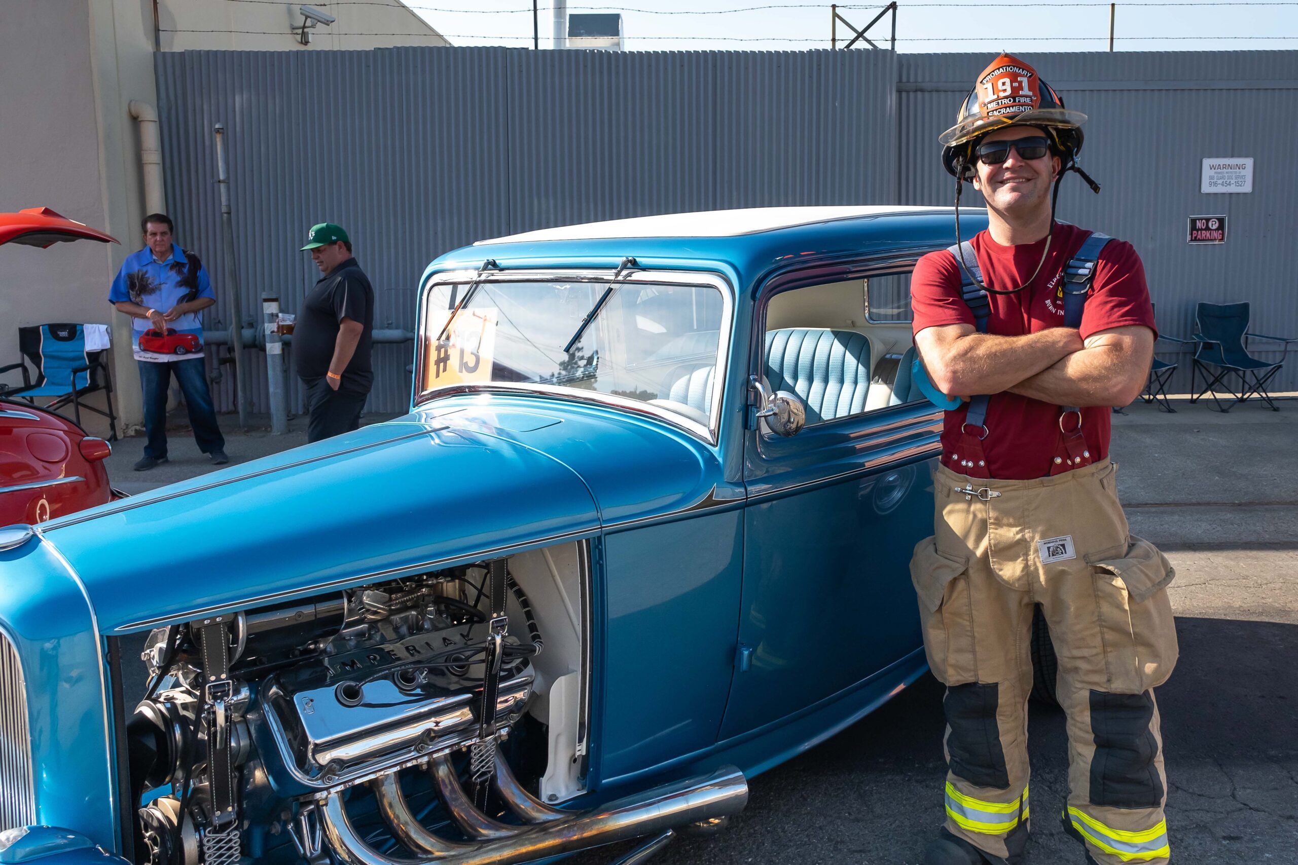 Firefighter standing next to hot rod