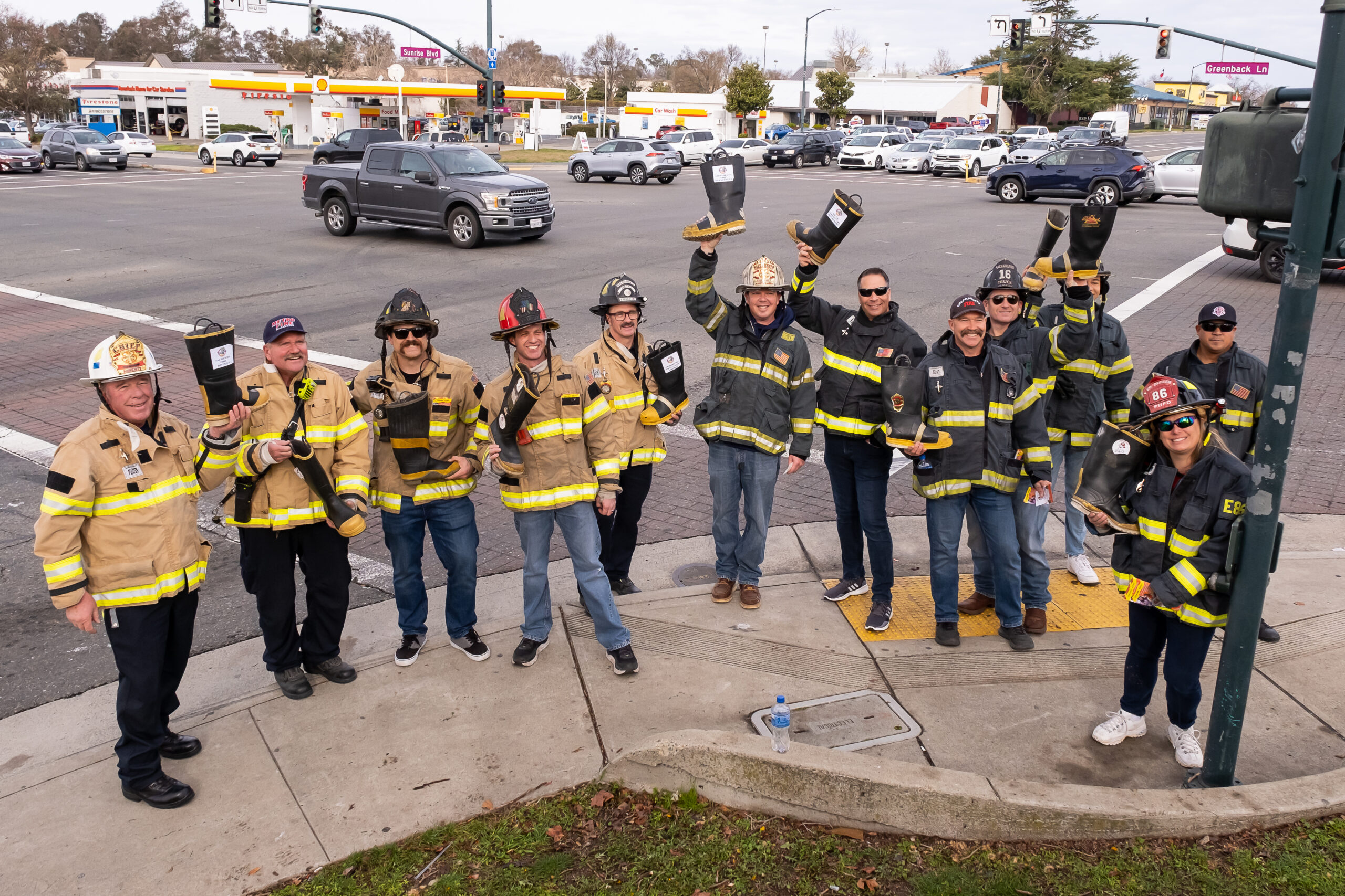 Group of firefighters at street corner holding boots