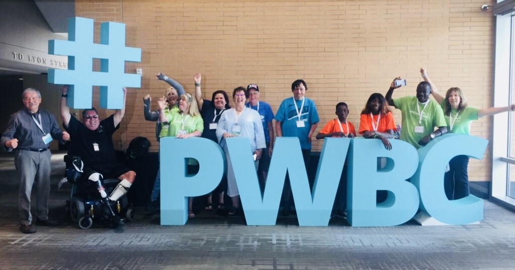 People posing behind block letters PWBC