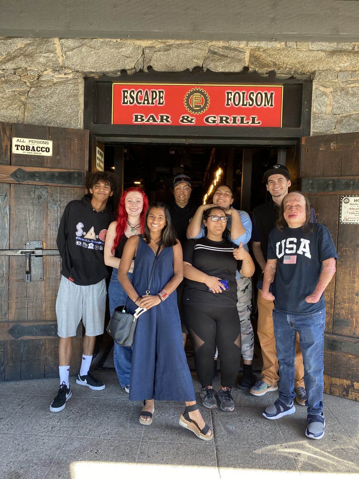Young adults posing in front of escape room